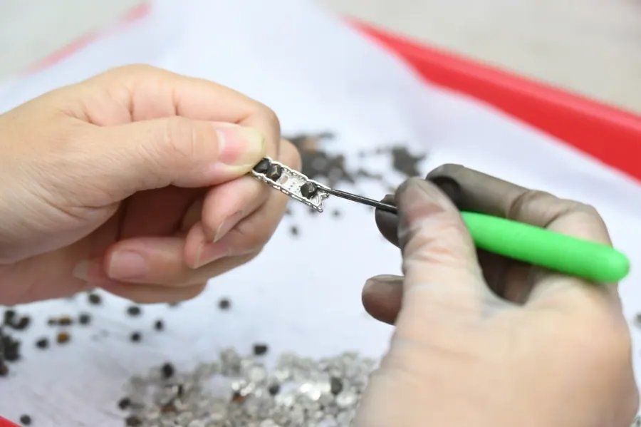 Hands performing jewelry setting work